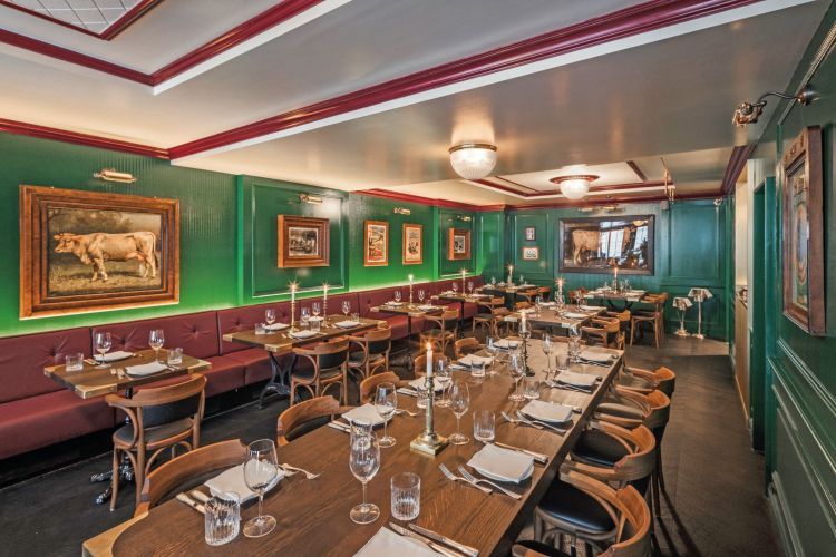 Gastraum des Williams Butchers Table in Zürich: grüne Wände, gedeckte Tische, Kerzenlicht